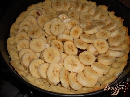 Бананы нарезать, сбрызнуть лимонным соком и уложить сверху на шоколад.