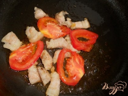 Добавить к мясу порезанный крупно помидор, посолить и поперчить.
