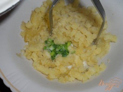 Молоко закипятить, добавить в него мелко порезанный зеленый лук. Кипятить около минуты.  Влить молоко с луком в картофель, посолить и поперчить по вкусу.
