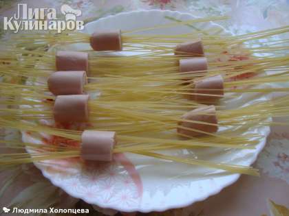 Нарезаем сосиски на 4-5частей и накалываем спагетти, лучше брать спагетти потолще, накалываем как кому хочется