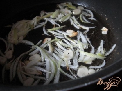 В глубокой сковороде на оливковом масле поджарить луковицу, нарезанную дольками и кусочки чеснока.