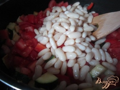 Добавить томаты, нарезанные кубиками и готовую фасоль. Посолить и поперчить, накрыть крышкой и потушить еще 10 мин.