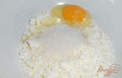 В творог добавить яйца, соль и сахар.