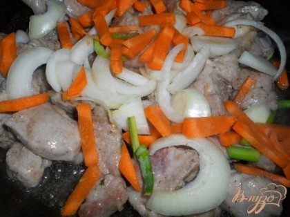 Выложить на сковороду с растительным маслом, обжарить немного. Добавить порезанный крупно лук и морковь.