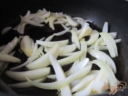 В сковороде на оливковом масле поджарить луковицу, нарезанную дольками.