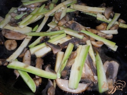 Все овощи порезать длинной соломкой. В сковороду выложить сначала грибы и кабачок.