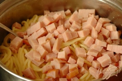 В готовые спагетти положить масло, перемешать, добавить молоко, взбитое с яйцом, ветчину (кубиками).