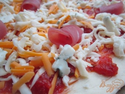 Для второй пиццы поверхность смазать томатным,готовым соусом (он уже с приправами и очень вкусный), посыпать тертый сыр, разложить аккуратно кусочки Рокфора, кусочки ветчины.Пиццу выпекать при 180 гр. до готовности .