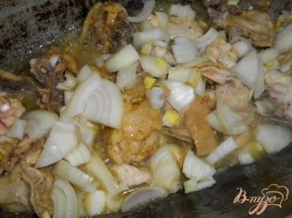 В гусятницу или другую толстостенную посуду влить масло, нагреть его и выложить куски курицы. Обжарить немного, поперчить, добавить специи.  Крупно нарезать лук.