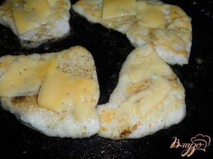 Перед тем, как убрать отбивные со сковороды, положить сверху каждой по пару кусочков сыра. Прикрыть крышкой буквально на пару минут пока сыр расплавится.