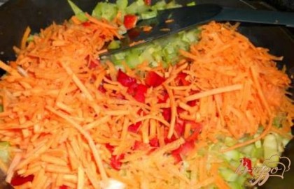 Морковь натереть на терке, перец болгарский и чили порезать и добавить к кабачкам. Все вместе обжарить 3-4 минуты.