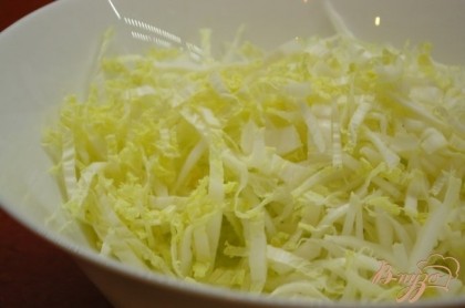 Тонко нарезать пекинскую капусту. Положит ее в миску.