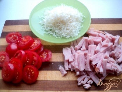 Ветчину порезать тонкими брусочками, помидоры черри пластинками, сыр натереть на терке.