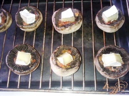 Достаем из духовки шляпки шампиньонов, кладем в каждую по кусочку сыра с плесенью и посыпаем порезанным зеленым луком, поливаем майонезом.