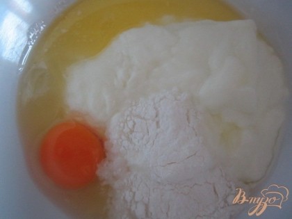 В салатник выложить йогурт, растопленное сливочное масло, яйцо, сахар и соль,  разрыхлитель. Размешать.