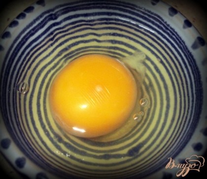 Довести  воду в кастрюле до кипения. Яйцо аккуратно выбить в маленькую посудину, так чтоб желток остался целым.