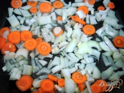 Порезать лук  и морковь, высыпать их в большую, глубокую сковороду и  поджарить на растительном масле.
