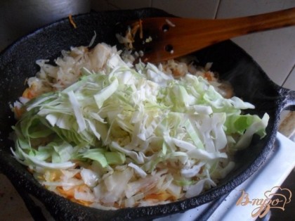 Добавить к овощам в сковороду квашеную капусту. Готовить помешивая 15 минут.Добавить свежую капусту. Готовить ещё 5 минут.