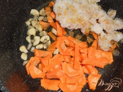 В сотейник наливаем немного масла, добавляем порезанную морковь, перец и чеснок и обжариваем.