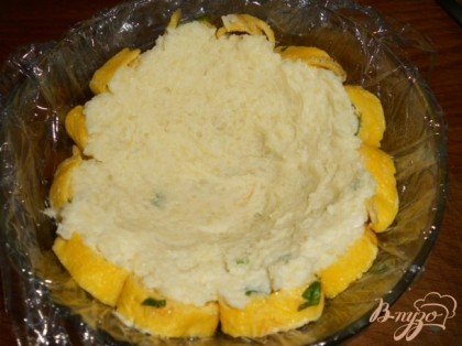 Картофель натереть на терке, смешать с майонезом и зеленым луком. Две трети картофеля плотно укладываем на омлетные спиральки.