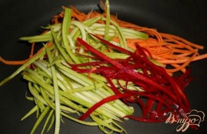 Морковь, кабачок и перец порезать тонкими, длинными полосками обычным или специальным ножом. Выложить в сковороду с растительным маслом и припустить их, не жаря, только, чтобы они стали немного мягкими.