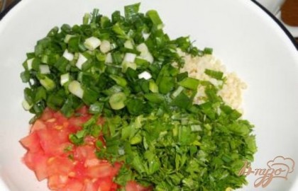 Петрушку, зеленый лук, мяту и кинзу мелко нарезать и добавить к булгуру с помидорами. Выдавить чеснок.