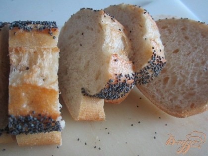 Нарезать хлеб на тонкие ломтики и подсушить на сухой сковороде.В оригинальном рецепте их нужно обжарить на  оливковом масле. Затем натереть со обеих сторон зубчиком чеснока.