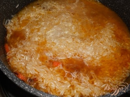 Всыпать рис и залить водой, на 2-3 пальца. Варить до готовности риса, не помешивая на слабом огне.