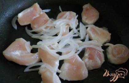На сковороду с маслом выложить порезанное кусочками куриное филе. Обжарить немного (не зажаривать). Добавить тонко нашинкованный лук.