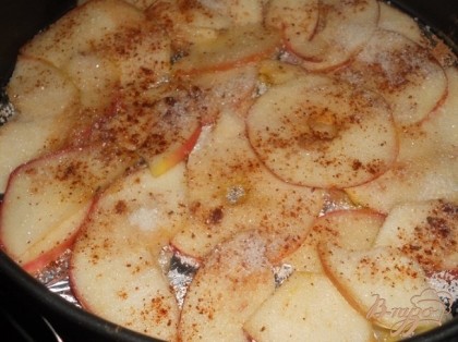 Уложить яблоки на дно формы, сверху посыпать ванильным сахаром и корицей.