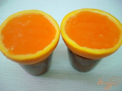 Апельсиновые чаши ставим на чашечки, для устойчивости.Заливаем в них желе и ставим в холодильник для застывания.