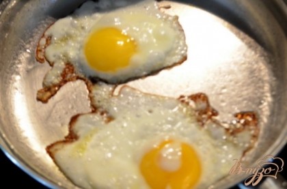 Приготовить яйца на сковороде ,обжаривать примерно 4 мин.