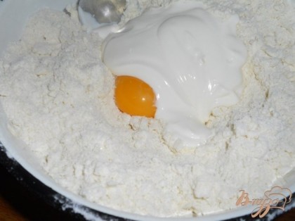 Растереть муку с маслом до крошки руками. Добавить сметану и желток 1 яйца.