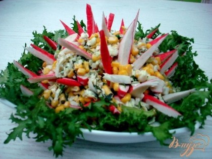 Готово! На дно тарелки выкладываем листья салата, по центру салат из пекинской капусты, который оформляем треугольниками из крабовых палочек.