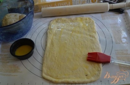 Разделить тесто на 2 части.Одну часть выложить на поверхность и раскатать скалкой в прямоугольную форму.Смазать растоплен.слив.маслом поверхность теста кисточкой.