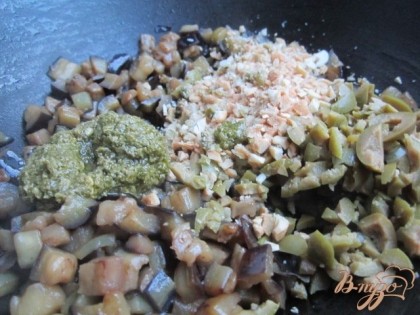 На сковороде на оливковом масле поджарить отжатые от лишнее жидкости баклажаны,добавить зеленое песто, рубленные оливки и орешки.