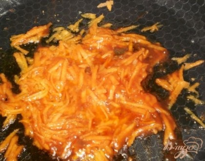 Морковь натираем на крупной терке и обжариваем ее на растительном масле вместе с томатной пастой.