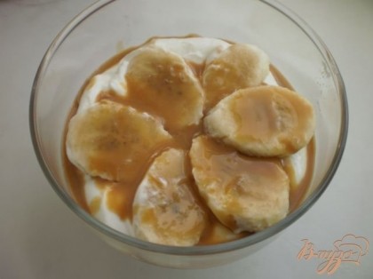 Затем опять слой бананов с карамельным соусом. Сверху на бананы выкладываем крем и посыпаем десерт орешками.