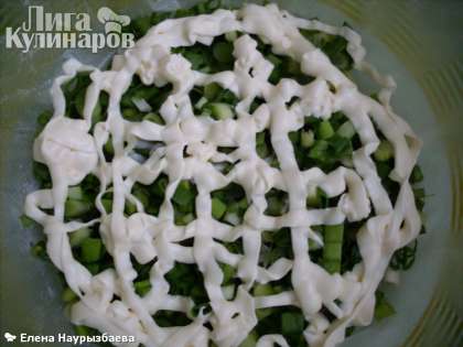 Форму выстлать пищевой пленкой. На дно густо насыпать накрошенный зеленый лук. Полить сеточкой майонеза. Это первый слой салата с печенью трески.