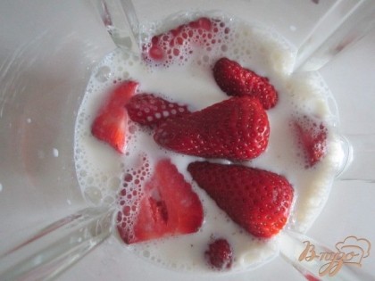 В блендер налить молоко, добавить ягоды клубники.