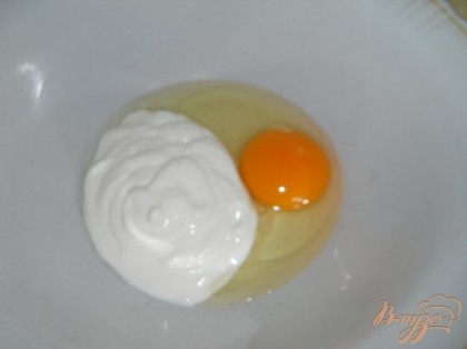 В глубокую посуду разбить яйцо и добавить сметану. Взбить.