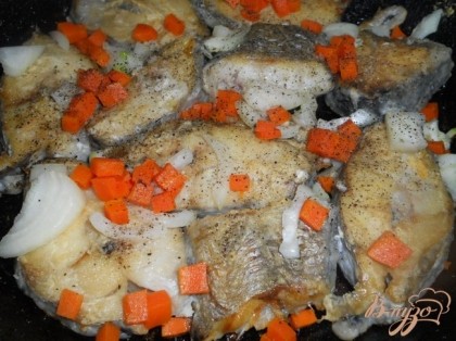 Добавить порезанный лук и морковь, немного рыбного бульона, поперчить, посыпать специями. Потушить на сковороде минут 5.