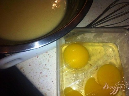 Снять миску с водяной бани, добавить яйца и быстро перемешать венчиком до однородности.