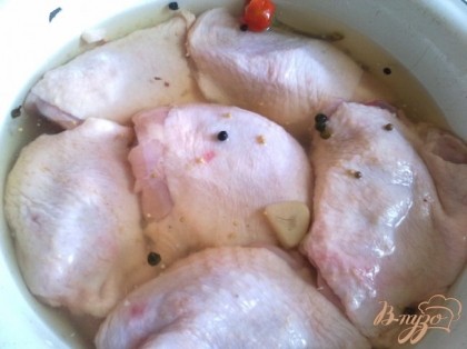 Моем куриные бедра и заливаем их маринадом от помидор на час.