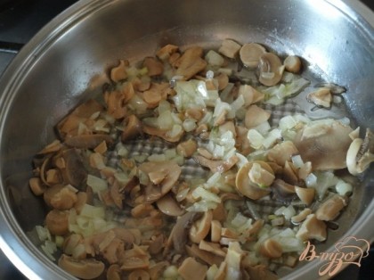 В сковороде растопить сливочное масло и обжарить на нём резанные шампиньоны с луком.