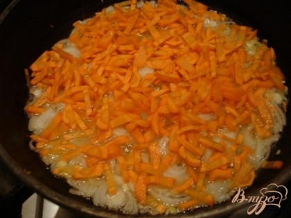 Добавляем морковь. Пассеруем на небольшом огне, чтобы овощи отдали в жир эфирные масла и вкус стал более насыщенным.
