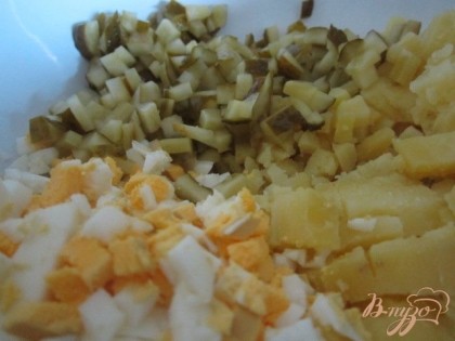 В салатник нарезать отварной картофель, яйца и маринованные огурцы на мелкие кубики.