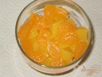 В вазу для десерта выкладываем нарезанные персики и мандарины.