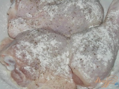 Куриные окорочка разделить на порционные кусочки, натереть солью и перцем, присыпать мукой.