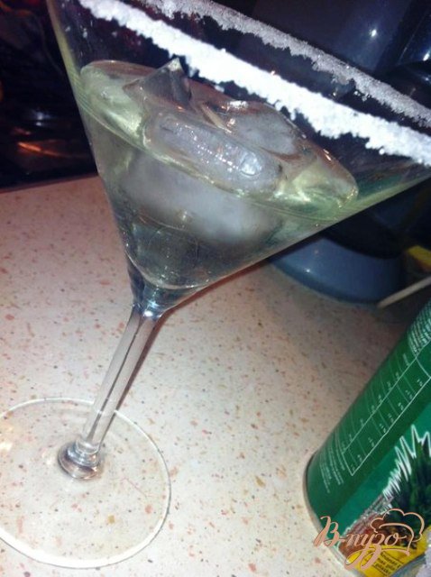На дно бокала положить лед и заполнить мартини